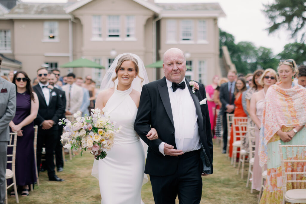 Bride walking down aisle at outdoor wedding ceremony, luxury wedding photography