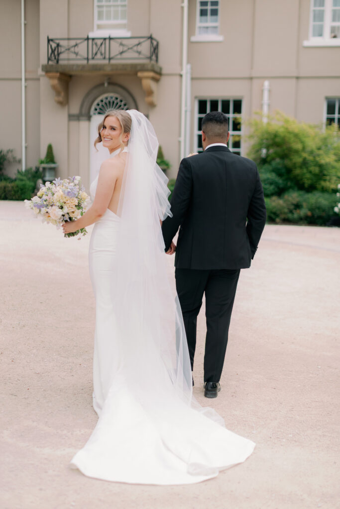 Bride and groom walking together at Burtonfields Hall, romantic wedding photos