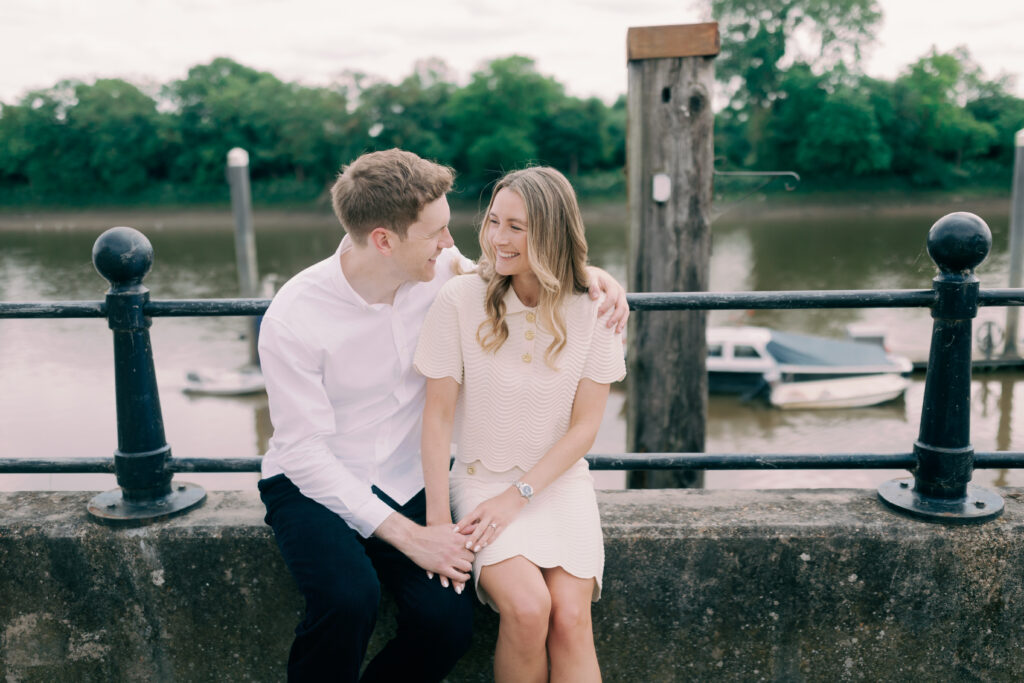 Romantic waterfront stroll with Chiswick Bridge background London engagement